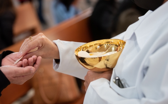 prêtre donnant l'eucharistie